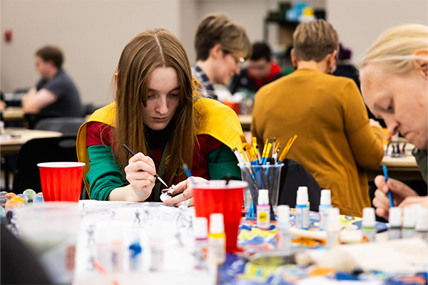 Two DSU students painting miniture figurines during Nanocon.